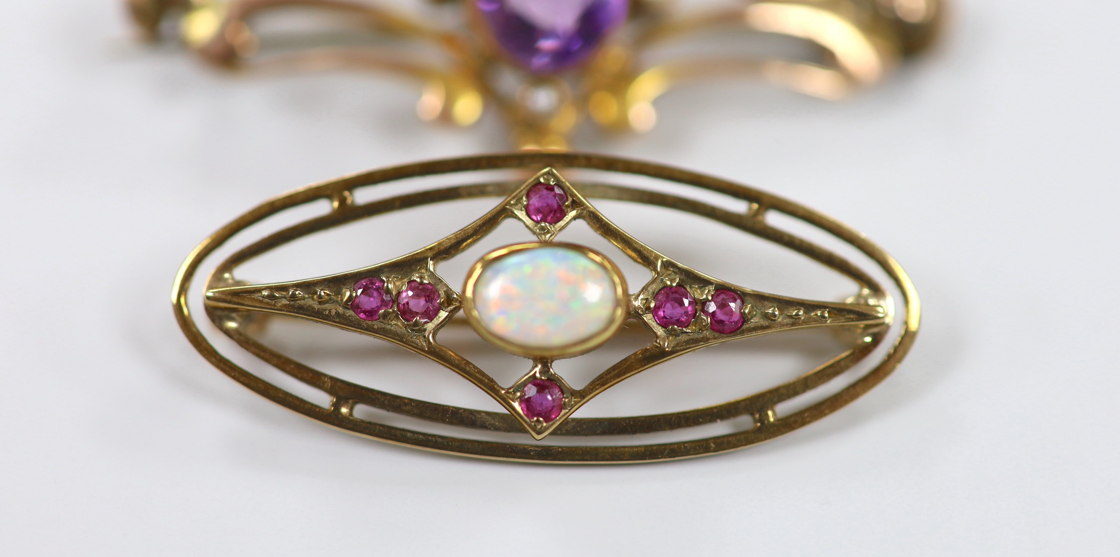 Two early 20th century yellow metal and gem set brooches, including amethyst and seed pearl, 45mm and white opal and ruby, gross weight 8.2 grams.